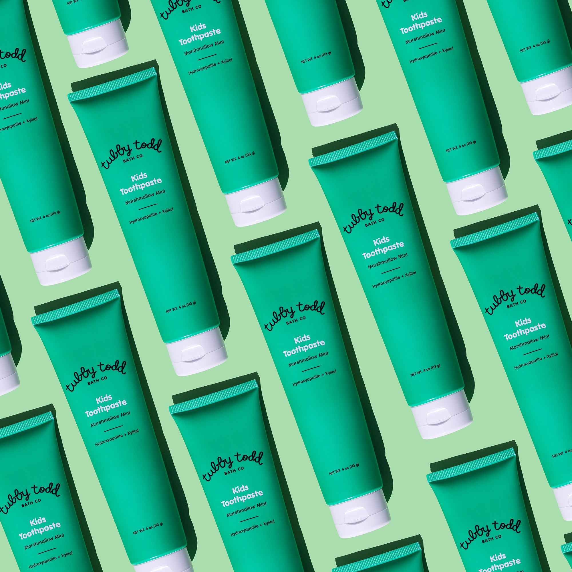 Pattern of green toothpaste tubes with white caps on a green background